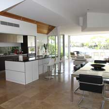 Brown tile floor in kitchen and dining room with tables and chairs